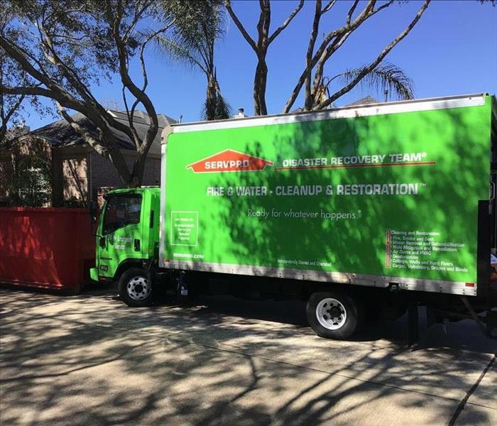 Box truck servpro and dumpster at site